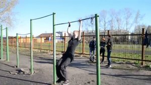 Девушка занимается на турнике