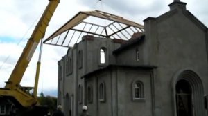 Подъёмный кран устанавливает целиком крышу на храм.