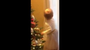 Нарядная годовалая дочь Леры Кудрявцевой ходит вокруг елки и рассматривает игрушки