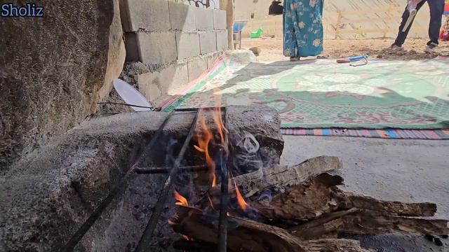 Documentary about nomadic family life: making a building and cooking meat daisy and children playin