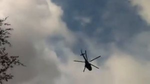 Вертолет низко летит над землей.