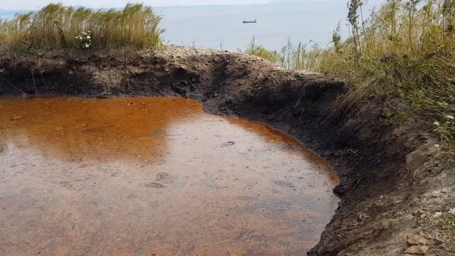 Мазутное озеро над бухтой Тихой с ручейком, стекающим в море смотреть онлайн