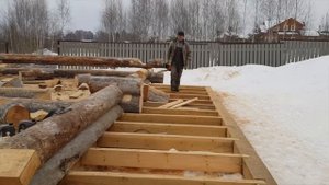 Укладка межвенцового уплотнителя в срубе из бревна