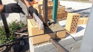 Сначала обложили дом кирпичом, а теперь строим забор заказчику.