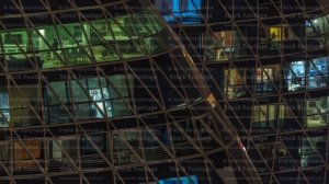 Frontal view of night facade of apartment building with a lot of windows with light timelapse.