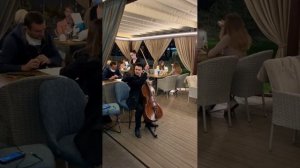 Красиво играет виолончелист, на летней террасе ресторана, в Киеве. Антон Степаненко, виолончелист.