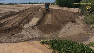 Shantui bulldozer clearing land with dump truck unloading sand & Dozer pushes sand into the water