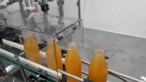 Розлив сока в стеклянные бутылки, закручивание крышек