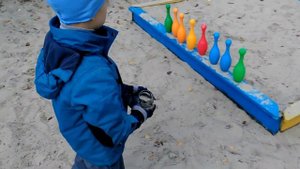 Играем в детский боулинг. Бросаем тапком по кеглям. We play in a children's bowling.