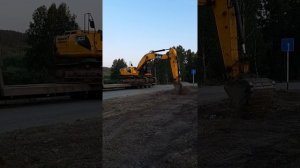 Экскаватор съезжает с трала