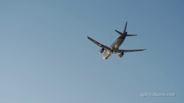 Эйрбас А320 авиакомпании Thai Smile взлетает в сторону океана в лучах закатного солнца.