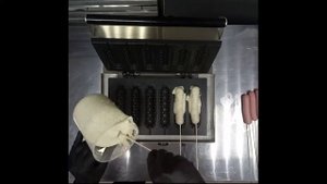 Аппарат для корн-догов в руках профессионального шеф-повара