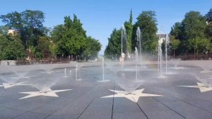 Дети купаются в фонтане.