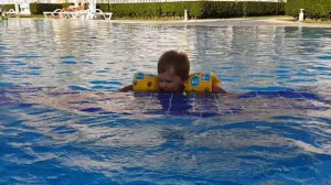 Ваня плавает в бассейне в нарукавниках POOL SHOOL.