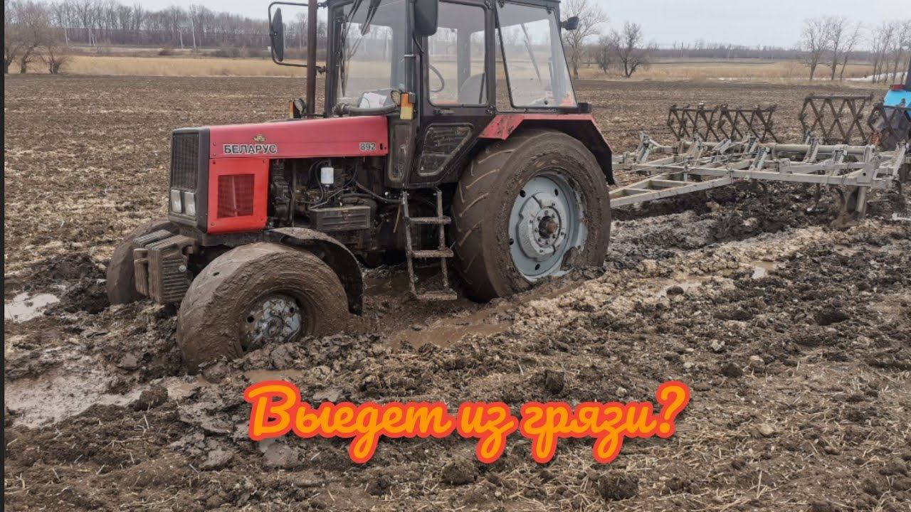 Трактор МТЗ 892 застрял с культиватором посреди поля.