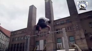 Человек в маске делает сложные трюки на турнике