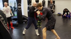 Отработка в комбинации бокового удара в парах на тренировке ММА