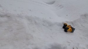 Машинки катаются на снежной горке.
