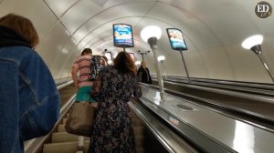 Подъем на эскалаторе на станции метро Невский проспект в Санкт-Петербурге и городской вид при выход