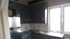 Кухня с глянцевыми  окрашенными фасадами серого цвета