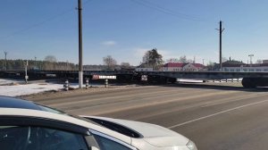 Грузовой поезд очень быстро едет через переезд в сторону России. 14.02.2022