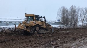 Бульдозер CAT D6R вскрывает грунт в январе.