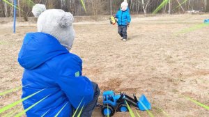 Мальчик на синем тракторе едет на ферму кормить животных.