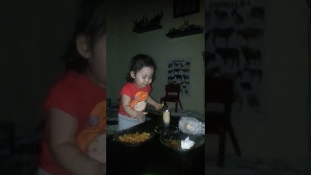 Toddler trying to blow out a candle