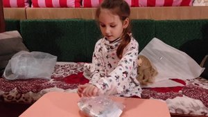 Эмили распаковывает куклу Реборн с длинными светлыми волосами .