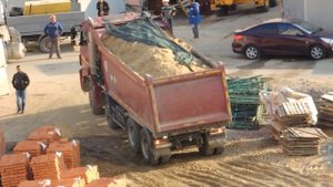 Kamaz Самосвал выгрузит песок на Поле возле стройки