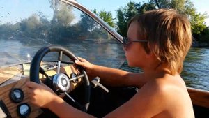 Руська за рулем лодки.