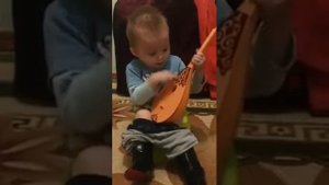 Ребенок играет на балалайке