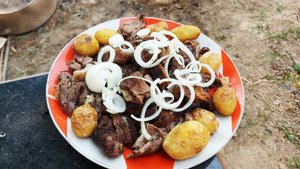 Баранина с чесноком и розмарином, запеченная на углях под землей