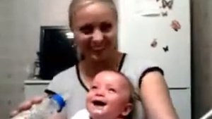 Малыш смеется на руках у мамы