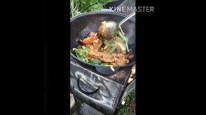 Корейка на кости с овощами в казане на огне