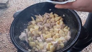 Картошка с мясом и грибами в казане на костре.