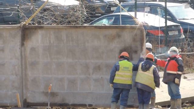 Землеройная машина Экскаватор, поднимает и стыкует бетонную стену, потом засыпает низ её землёй.