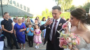 Молодожёны откусывают по кусочку от свадебного каравая