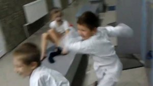 Дети в кимоно играют и дерутся в раздевалке.