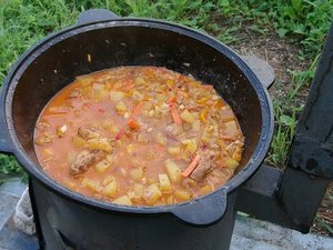 готовлю овощное рагу в казане на костре