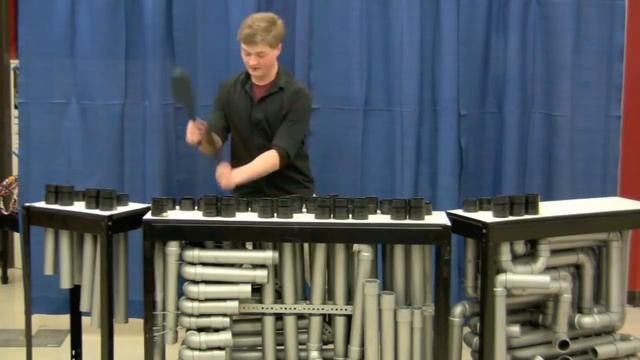 Парень играет известные песни на инструменте из труб смотреть онлайн