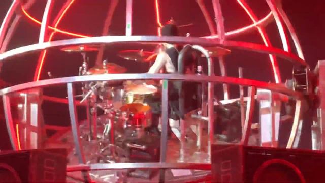 Travis Barker drumming in an upside down cage