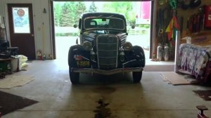 1935 Ford coupe pulls out of garage as it is prepared for 2,300-mile race