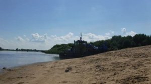 Играют дети в песке на пляже-Баржа с краном на Волге