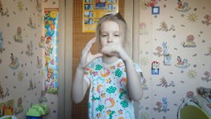 Маленькая девочка показывает пантомиму пальцами