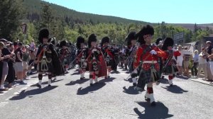Drum Majors lead the combined Pipe Bands over river Dee marching to 2022 Ballater Highland Games