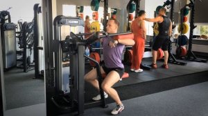 Махи рук в стороны в тренажере для тренировки средних дельт плеч