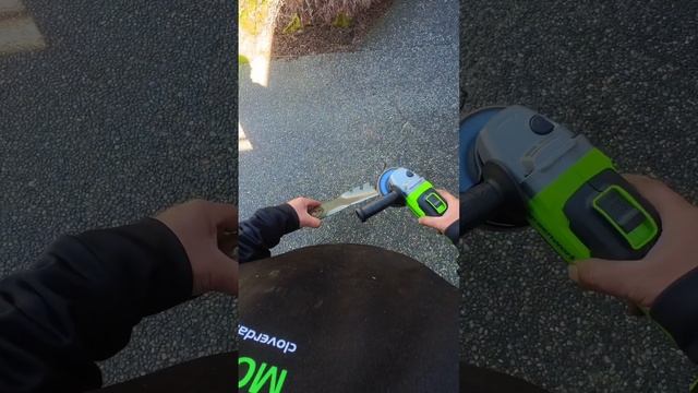 Greenworks 24 volt cordless angle grinder with brushless motor sharpening lawn mower blades.