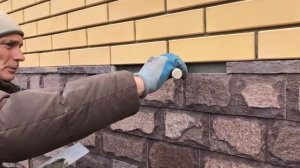 Отливы из камня при отделке цоколя дома из кирпича плиткой со сколом.