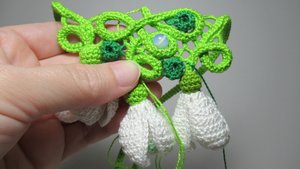 Прикрепляю вязаный цветок подснежника к третьему колечку в вязаном крючком колье